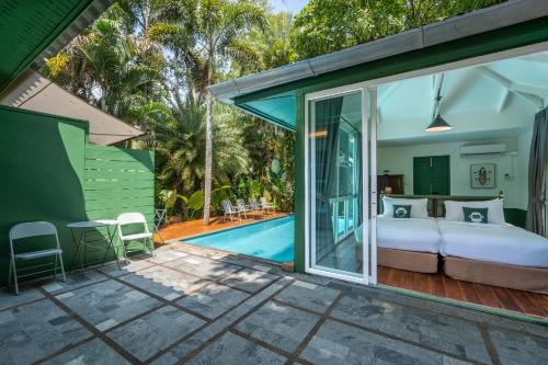 Tha Lane BayBlu Monkey Pooltara Krabi Hotel & Villas Pet Friendly的一间卧室设有一张床和一个游泳池