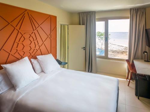 PamandziIbis Styles Mayotte Aéroport的一间卧室设有一张大床,享有海景
