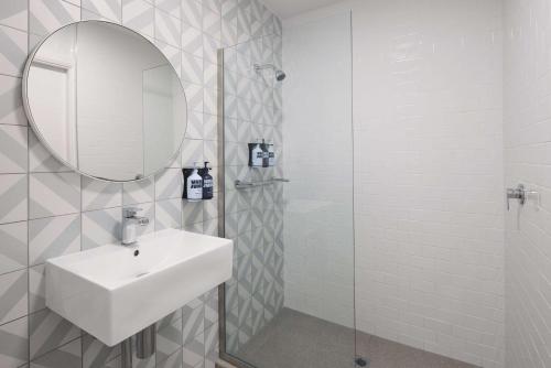 悉尼阿尔提莫酒店的白色的浴室设有水槽和镜子