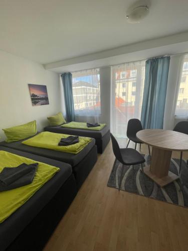 多特蒙德多特蒙德城市膳食公寓的客房设有两张床、一张桌子和一张桌子以及椅子。