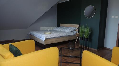 SikorzynoZielone Tarasy na Kaszubach的一间卧室配有一张床和两张黄色椅子