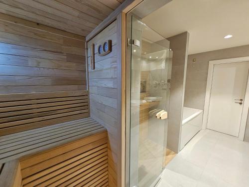 GračanicaHotel ETNA的设有带木墙的浴室内的步入式淋浴间