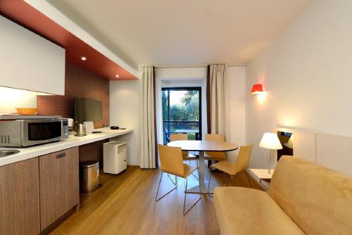 戛纳雷希德亚高级酒店的厨房以及带沙发和桌子的客厅。