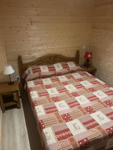 格尔姆Appartement 4 personnes - Hautes-Pyrénées- Village de Peyragudes Peyresourdes - Vue exceptionnelle sur la montagne的一间卧室配有一张带红色和棕色被子的床