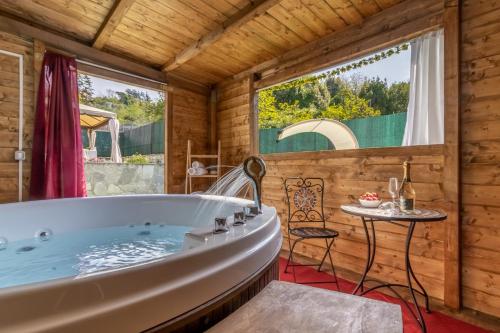 斯培西亚Luxury Summer House的木房设有浴缸,配有桌子