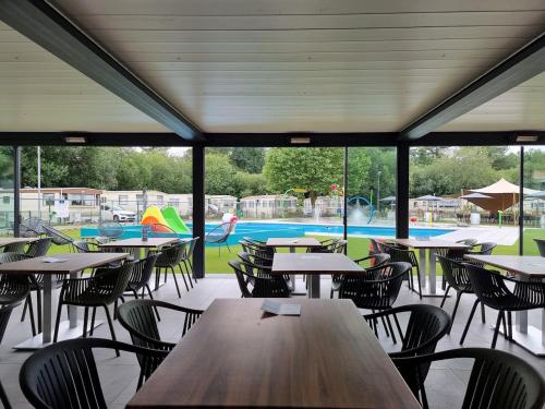 RijkevorselVakantiepark Breebos的一个带桌椅的自助餐厅和一个游泳池