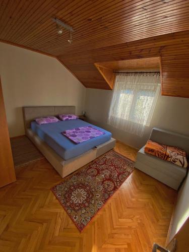 特雷比涅Apartman Trebinje的一间卧室设有床、窗户和地毯。