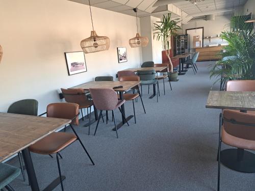 克拉姆福什Kramfors Stadshotell AB的用餐室配有桌椅和盆栽植物