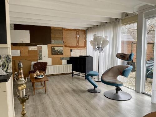 诺德克豪特Attractive holiday home in Noordwijkerhout with garden的客厅配有椅子和电视