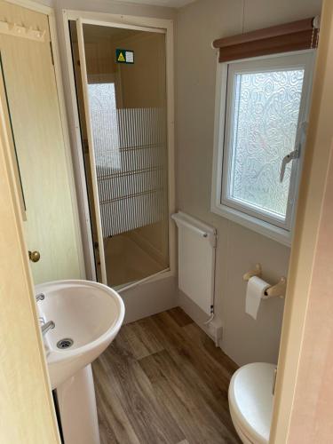 斯凯格内斯Charming 6 birth caravan in skegness的一间带水槽和卫生间的浴室以及窗户。