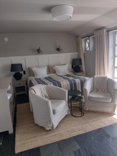 维塞乌卡维塞乌卡维拉公园酒店&spa的一间卧室配有一张床和两把白色椅子