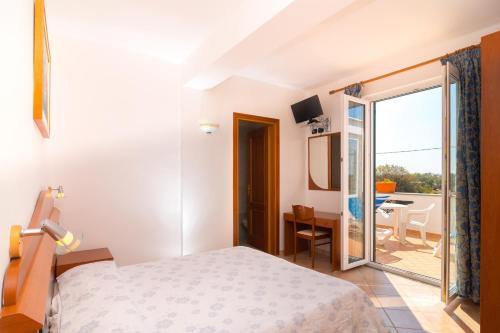 伊斯基亚佛米瑞尔别墅酒店的酒店客房设有一张床和一个阳台。