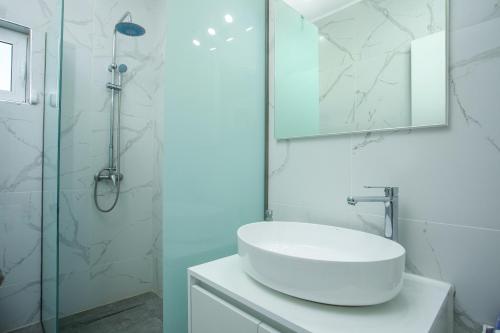 拉多斯VillaPhysis with Private Pool的白色的浴室设有水槽和淋浴。