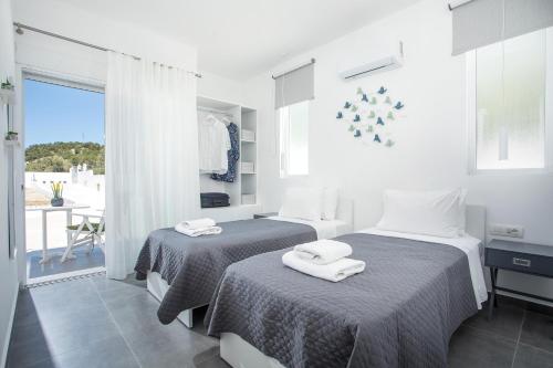 拉多斯VillaPhysis with Private Pool的一间卧室配有两张带毛巾的床