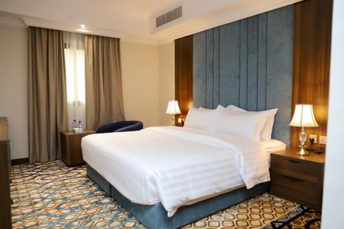 奥朱贝尔Hola Hotel的酒店客房设有一张白色大床和椅子
