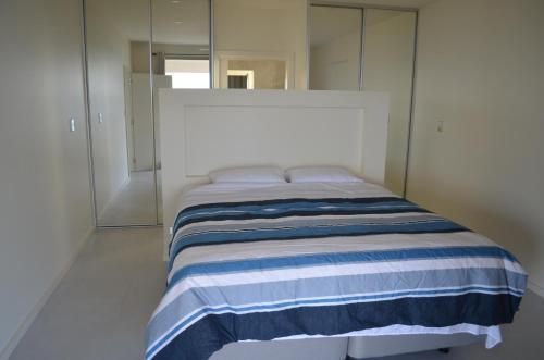 Vivonne Bay库帕兰达梦想度假屋的一间卧室配有一张带蓝白条纹毯子的床