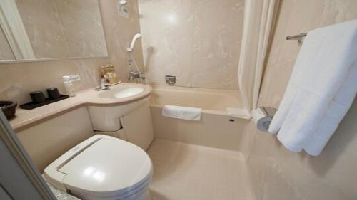 长崎Dormy Inn Nagasaki Shinchichukagai的白色的浴室设有卫生间和水槽。