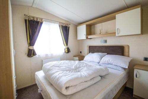 大雅茅斯Brilliant 8 Berth Caravan At Haven Caister Holiday Park In Norfolk Ref 30024d的卧室配有一张大白色床和窗户