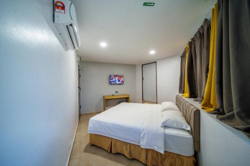 士毛月Hotel Uptown Semenyih的小房间设有床铺和电视