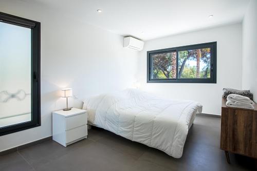 格里莫Villa Ryx的白色的卧室设有床和窗户