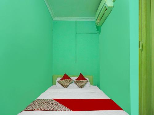 秾莎OYO 92496 Faraas Homestay Syariah的一间卧室设有一张红色和蓝色的墙壁床。