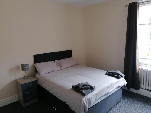 阿什比德拉祖什The Queens Head的一间卧室配有一张带黑色床头板的床和窗户