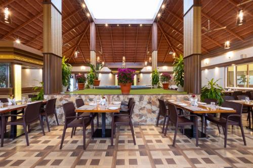 奇克马格尔Honeydewwz Exoticaa Hotel & Resort的大楼内带桌椅的餐厅