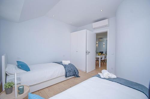 卡斯卡伊斯Central & Stylish 2 Bedroom Apartment w/ Balcony的白色卧室配有两张床和一张桌子