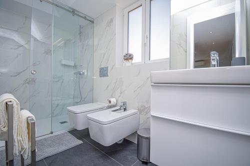 卡斯卡伊斯Central & Stylish 2 Bedroom Apartment w/ Balcony的一间带水槽、卫生间和淋浴的浴室