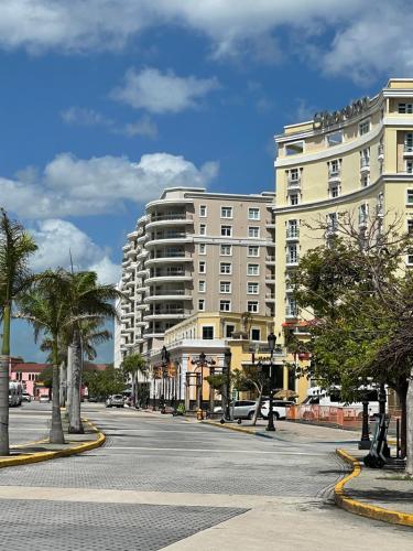 圣胡安纳沃纳酒店的一条有两栋白色大建筑和棕榈树的街道