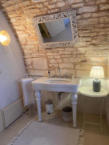 马丁纳弗兰卡PalazzOliva - Boho chic Guest house in the historic heart of Martina Franca的一间带水槽和镜子的浴室