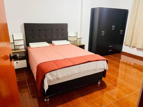 塔克纳Departamento Amplio Pérez Gamboa的一间卧室配有一张床和一个黑色橱柜
