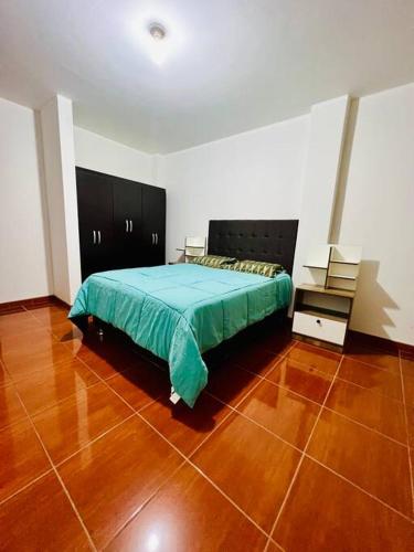 塔克纳Departamento Amplio Pérez Gamboa的一间卧室配有一张床,铺有木地板