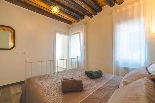 基奥贾Casetta Stretta Bersaglio的一间卧室设有一张大床和两个窗户。