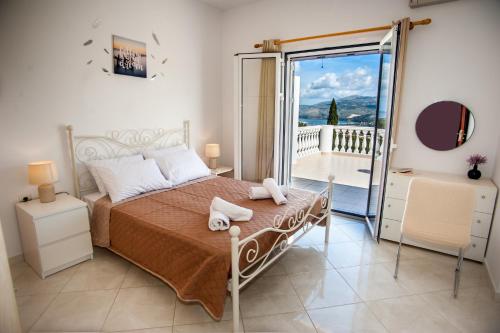 阿尔戈斯托利翁Nikos Apartments Spacious and Panoramic的一间卧室设有一张床和一个滑动玻璃门