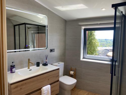 卢戈Siente Muralla的一间带水槽和卫生间的浴室以及窗户。