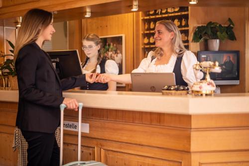 伯布林根族瑞特酒店及餐厅的两个女人站在酒吧里跟顾客说话