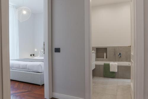 布里维奥Como Lake Vista - by MyHomeInComo的一间带一张床的卧室和一间带镜子的浴室