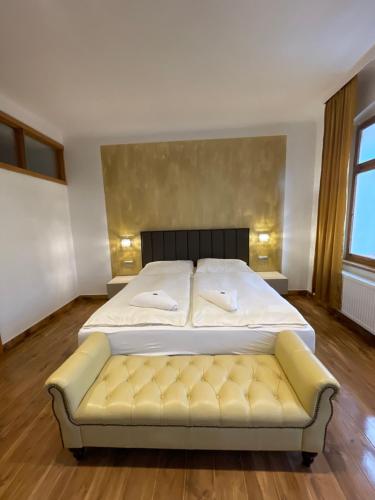 洛克特Pension & Restaurant Atmosféra的一间卧室配有一张床和一张黄色的沙发