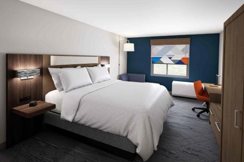 埃文斯维尔Holiday Inn Express & Suites Evansville Downtown, an IHG Hotel的卧室配有一张白色大床和一张书桌