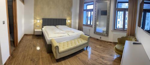 洛克特Pension & Restaurant Atmosféra的一间卧室配有一张床、一张沙发和窗户。