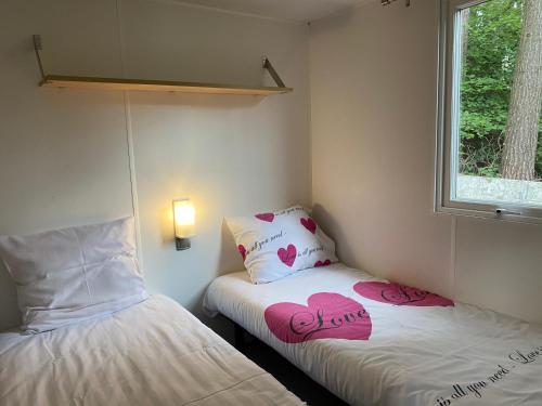 LilleVerblijfpark De Brem的小房间设有两张心形床