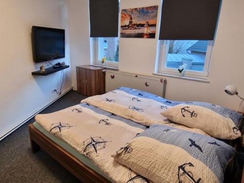 不来梅港Küstenliebe的配有电视的客房内的两张单人床