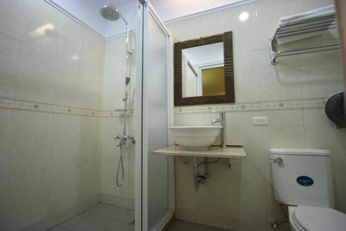 垦丁大街一个杯子旅店的一间带水槽、卫生间和镜子的浴室