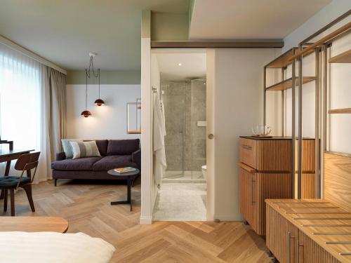 苏黎世圣约瑟夫酒店的带沙发和玻璃淋浴间的客厅