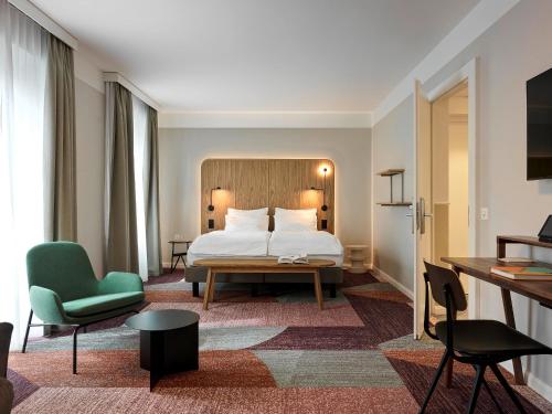 苏黎世圣约瑟夫酒店的酒店客房,配有一张床和一把绿色椅子