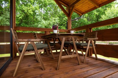 NarewkaGroszkówka的木制甲板上的木桌和椅子
