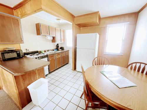Rapid RiverHillcrest Inn & Motel的厨房配有桌子和白色冰箱。
