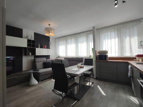 克沃兹科Komfortowy Apartament w Kłodzku的厨房以及带桌椅的起居室。