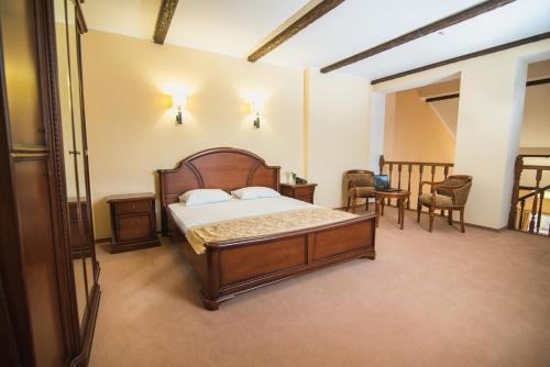 波利亚纳Ruta Resort Polyana的卧室配有一张床和一张桌子及椅子